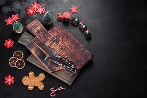 Christmas homemade gingerbread cookies, spices and cutting board on dark background photo