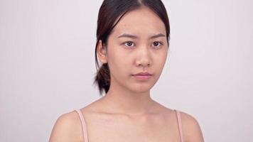 mejora la piel de la cara de una chica asiática con maquillaje natural de piel áspera a piel agradable. video