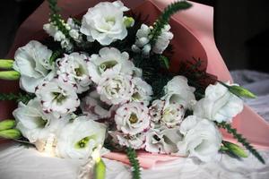 Festive white bouquet of flowers on a dark background, garland, pink color bouquet photo