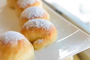 Homemade fresh breads with powdered sugar on top in white plate photo