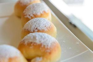 Homemade fresh breads with powdered sugar on top in white plate photo