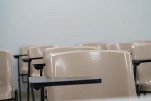 Empty class at university or school with chairs and side table, the chairs are arranged in rows. photo