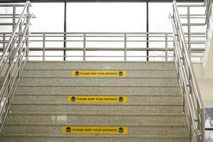 mantenga su etiqueta de distancia en las escaleras o el edificio de la universidad. etiqueta de distancia real. etiquetas amarillas rectangulares. foto