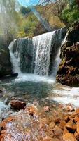 una foto vertical de una cascada en la naturaleza