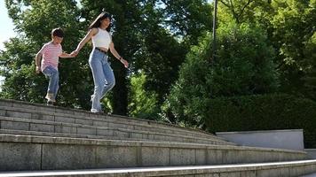 mutter und sohn kind glücklich zusammen in einem sommerpark die treppe hinunterlaufen video