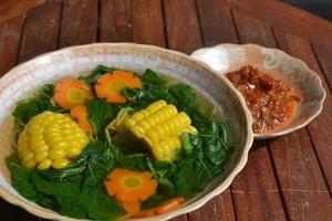Spinach soup with carrots and corn is traditional Indonesian food photo