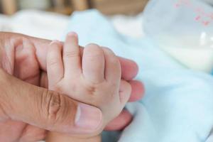 baby holding father's hand photo