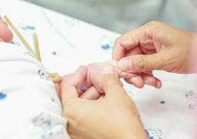 The nurse's hands are on the baby's veins to prepare the injection in a hospital. photo