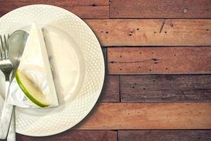 Top view Thai style lime cream cake on white ceramic plate on vintage tone colors. photo