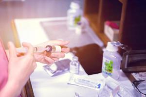 A picture of nurse hands in preparation an injection vaccine for the patient in blue light tone with light flare. photo