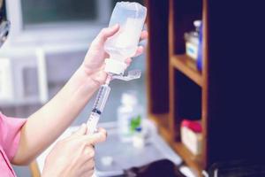 A picture of nurse hands in preparation an injection vaccine for the patient in blue light tone. photo