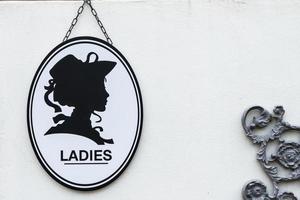 Toilet sign in vintage or classic style lady or woman symbol on wall WC. photo