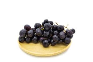 Fresh grapes on wooden plate isolated on white background photo