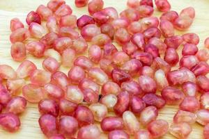 Closeup of fresh seed pomegranate on wooden plate photo