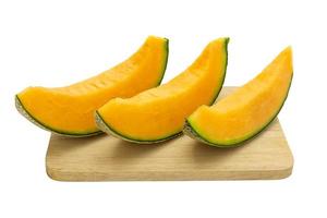 Closeup melon bright colors that is pieces on wooden tray isolated on white background. photo