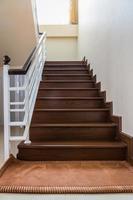 Staircase custom built home interior with wood staircase and white walls. photo