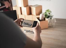 A woman using a mobile phone to take glasses photo