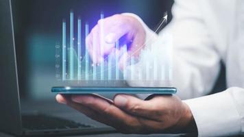 young businessman using the phone To analyze stock market growth charts photo