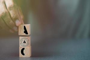 Man's hand holding a wooden block photo