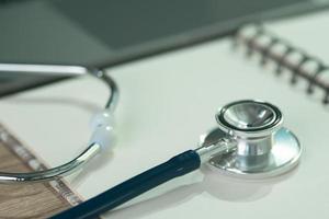 A stethoscope placed on a white notebook photo