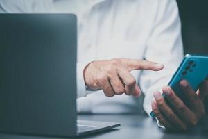 Young businessman's finger pointing to mobile phone, photo