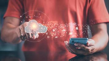 A young businessman uses a smartphone and touches the cloud through a virtual screen. , Communication with cyberspace technology connects new innovative online networks around the world. photo