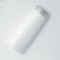White cosmetic bottle on the water surface. Blank label for branding mock-up. Flat lay, top view. photo