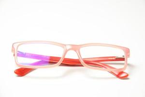 Pink eyeglasses on white photo