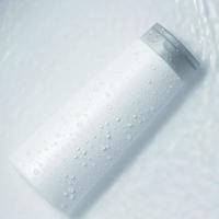 botella cosmética blanca en la superficie del agua. etiqueta en blanco para maqueta de marca. endecha plana, vista superior. foto