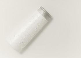 White cosmetic bottle on the water surface. Blank label for branding mock-up. Flat lay, top view. photo