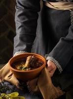 A vertical shot of a chef serving a gourmet dish photo