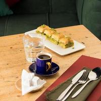 A cup of coffee near glass of water and baklava photo