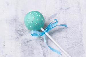 A blue cake pop on a textured background photo