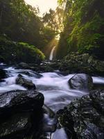 Beautiful morning view in Indonesia. Panoramic view of the waterfall with the beauty of natural sunrise light photo