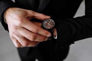 businessman looks at the watch on his wrist, looks at the time. High quality photo