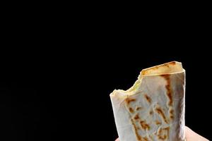 bit off a pita bread, fajitas, burrito, shawarma on a white background photo