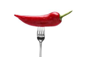 side view of red pepper on fork on white background. Domestic cultivation. Fresh vegetables. Vegetarian dinner. Paprika on a fork. Isolated from background photo