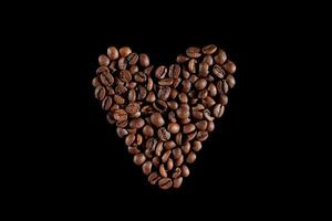 Coffee beans in the form of heart. Coffee on a black background. top view. macro photo