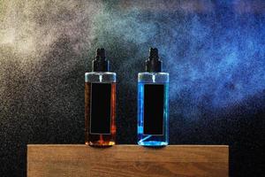 two bottles with yellow and blue liquid. two spray spraying cans on black background on wooden stand. mockup on cans, jars. selective focus. barbershop. tool for hairstyles and beards photo