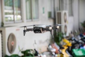 nobody, modern black drone flying in a building with 4 propellers, 4k camera photo, and video. The concept for professionals in the unmanned aircraft technology industry. Close up, Blur background. photo