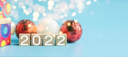 The wooden cube with the word 2021 changes to 2022. New Year Christmas Day. Concept on bokeh and blue background. Close up and copy space on right for design or text. photo