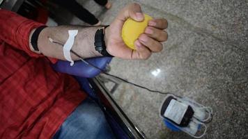 doador de sangue no campo de doação de sangue realizado com uma bola inflável segurando na mão no templo balaji, vivek vihar, delhi, índia. também imagem conceitual para o dia mundial do doador de sangue em 14 de junho de cada ano video