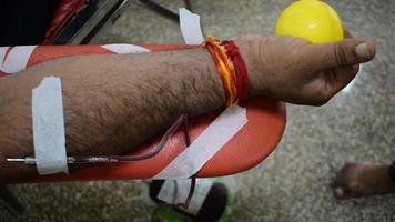 doador de sangue no campo de doação de sangue realizado com uma bola inflável segurando na mão no templo balaji, vivek vihar, delhi, índia. também imagem conceitual para o dia mundial do doador de sangue em 14 de junho de cada ano video