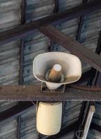 The old megaphone is hanging on the metal beam of the building. photo