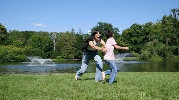 moeder en zoon kind blij rennen samen ronddraaien in een zomerpark video