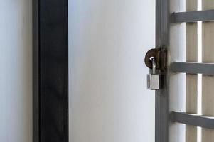 The brass padlock locks the metal fence of the urban house. photo