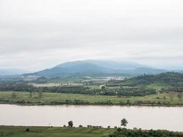 gran río tranquilo cerca de la granja y el pueblo de campo. foto