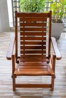 The reclining wooden chair on the terrace of the urban house. photo