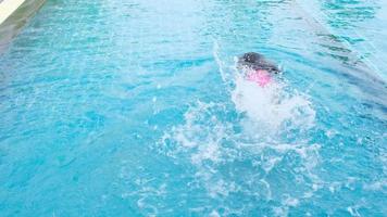 Happy little sisters are swimming and playing in outdoor swimming pool in a tropical resort during family summer vacation. Kids learning to dive and swim. Healthy Summer Activities for Kids. video