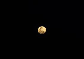 la vista de la luna llena brilla en la noche oscura. foto